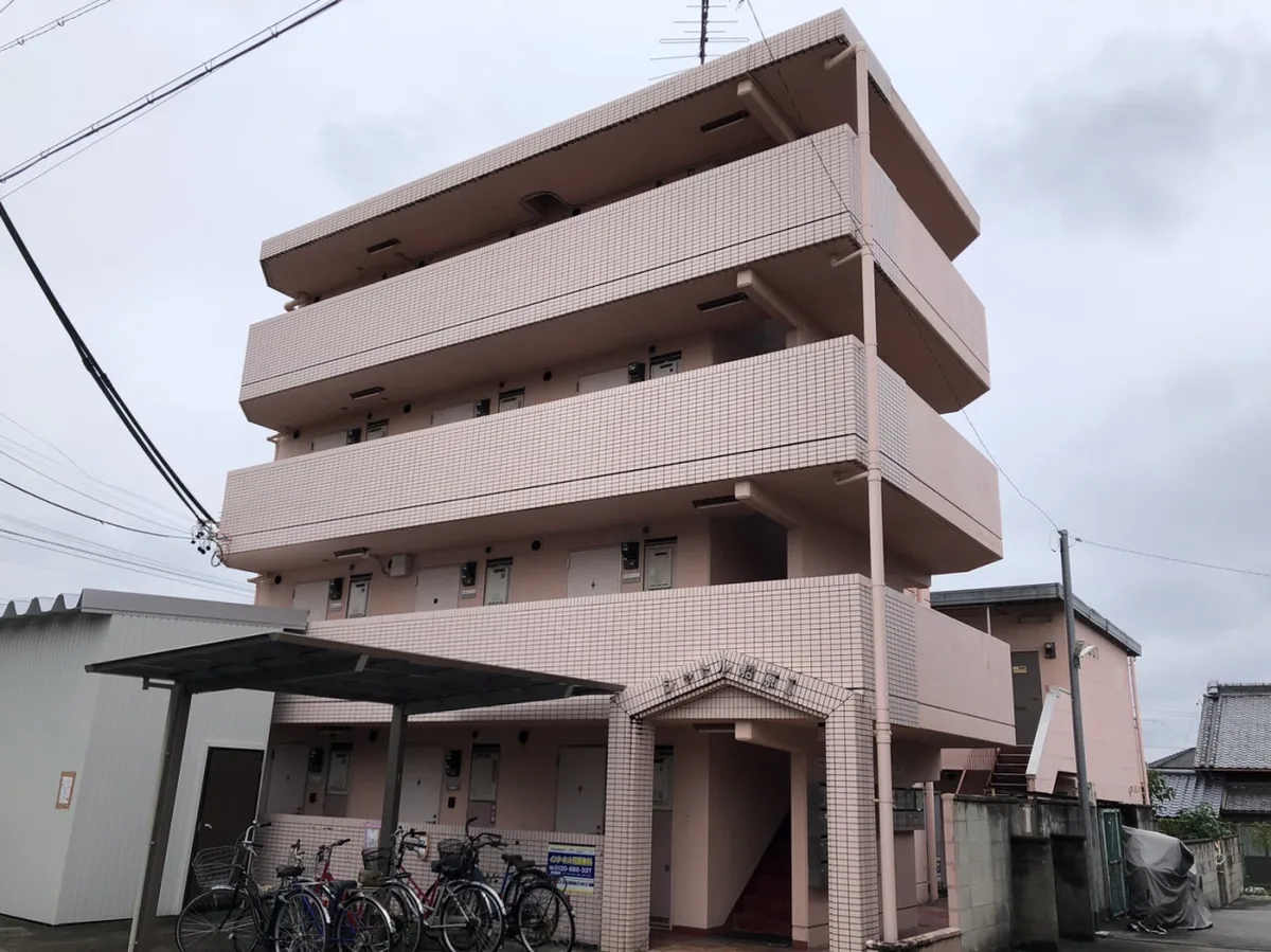 施工前。ピンクのタイル張り4階建てマンション